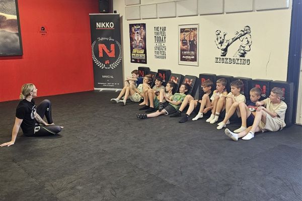 Gevel van een deelnemend bedrijf met kinderen in de deuropening